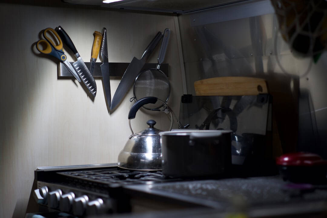 Kitchen counter with knives, scissors, and kettle.