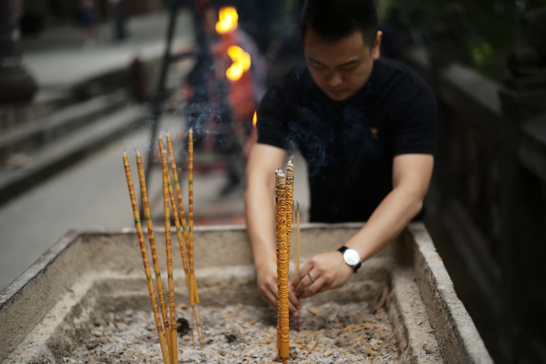 Man lighting incense sticks in a temple